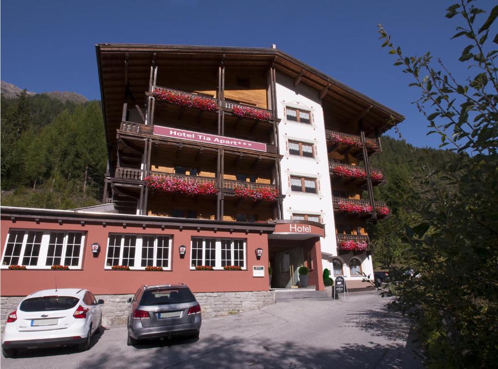 un edificio con coches estacionados frente a él en Hotel Tia Apart, en Kaunertal