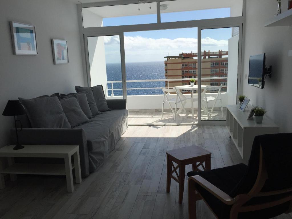 sala de estar con sofá y vistas al océano en vacaciones frente al mar, en Candelaria
