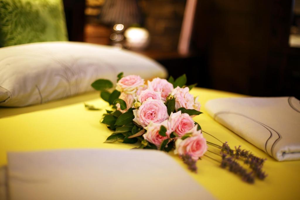 a bouquet of pink roses sitting on a bed at Apartments Villa ViDa Orebić in Orebić