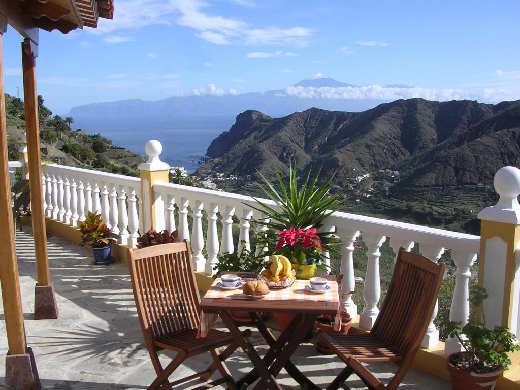 una mesa y sillas en un balcón con vistas en Casas Rurales El Serrillal en Hermigua