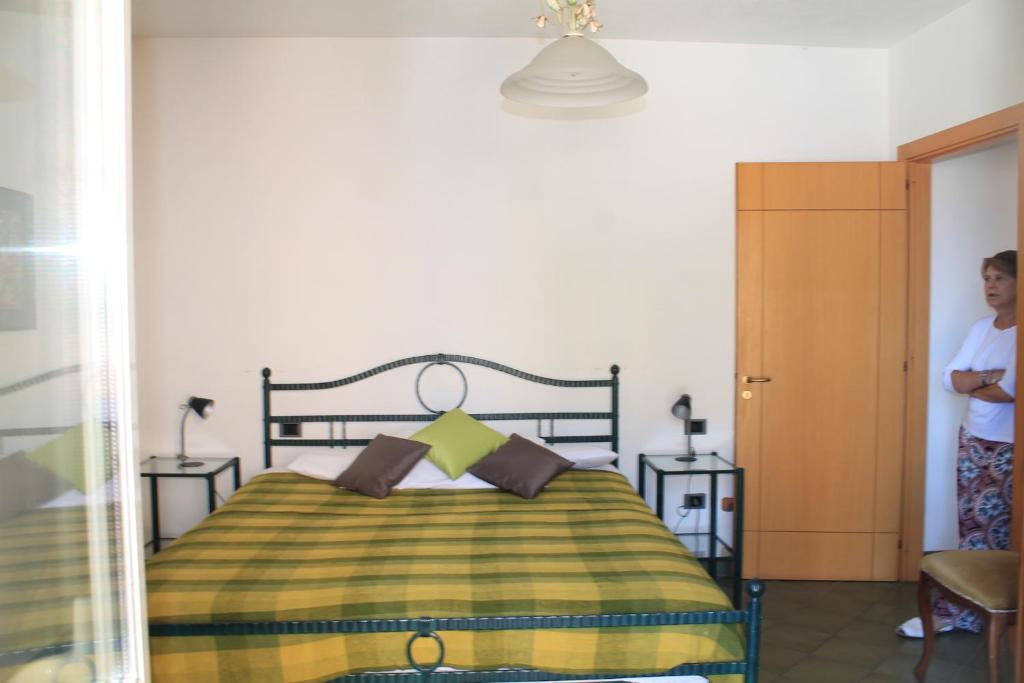 a person standing in a bedroom with a bed at Sardegna Santa Teresa Gallura, moto garage, centre sea view, wifi fibra, mare 300m centro 200 m in Santa Teresa Gallura