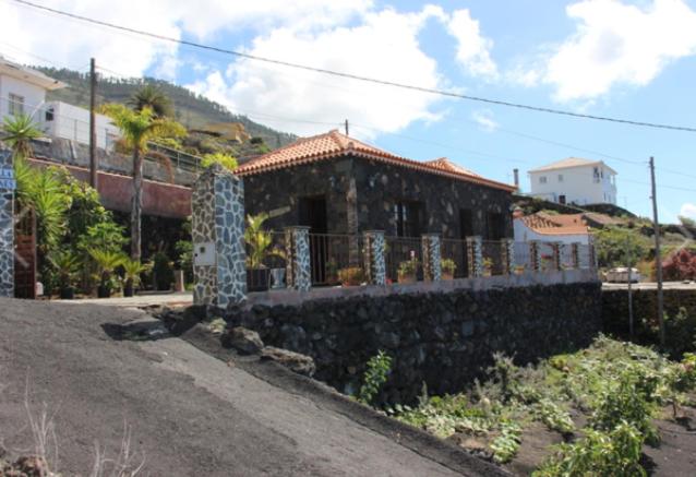 a house on a hill with a train in the background at Casa Bienes in Fuencaliente de la Palma