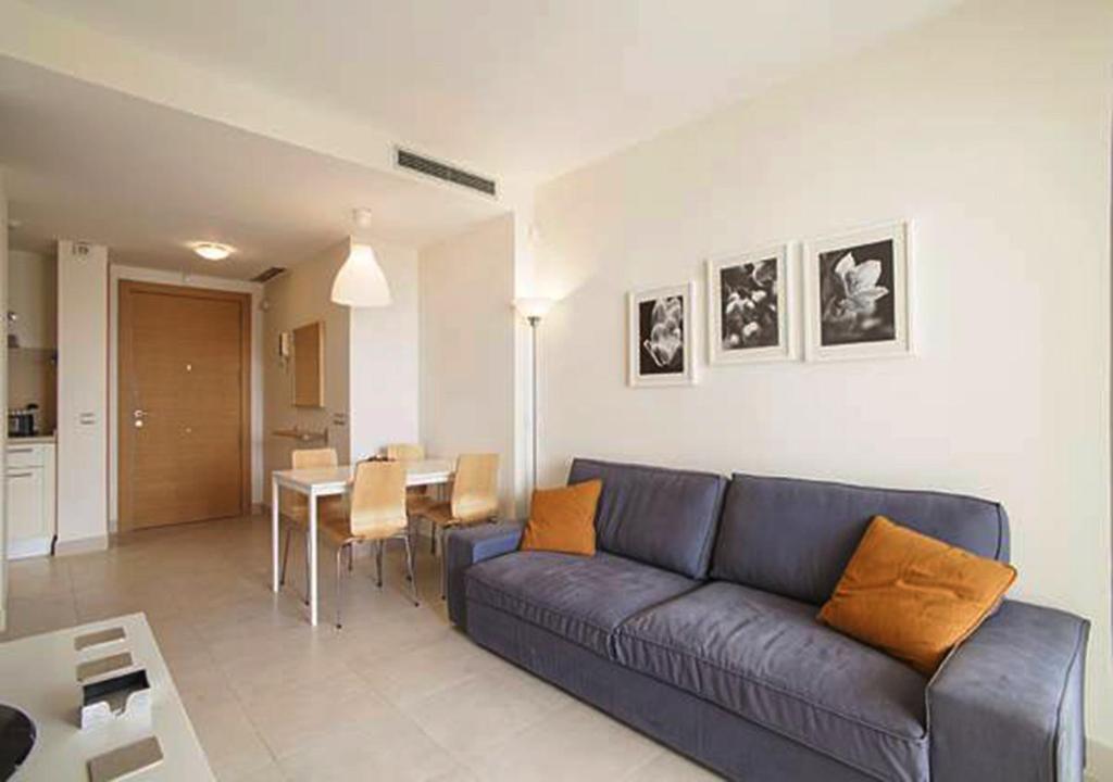 a living room with a blue couch and a table at Samara Marbella Apartment in Marbella
