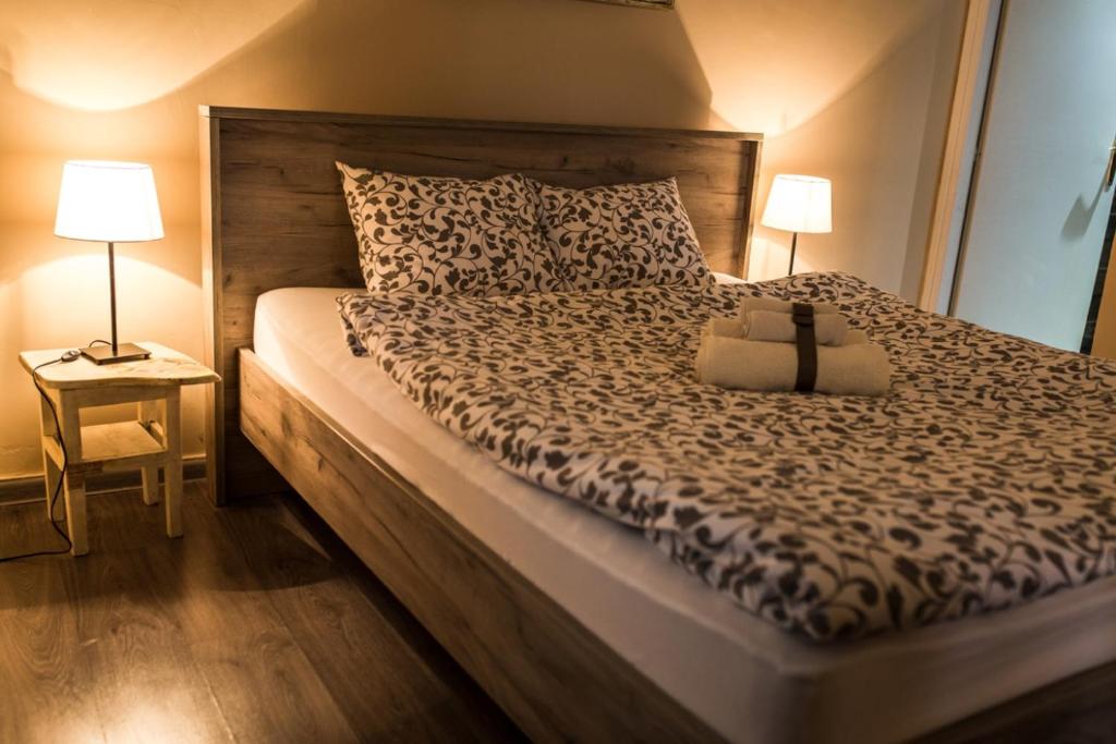 a bedroom with a bed with a black and white comforter at Top Apartment in Niš