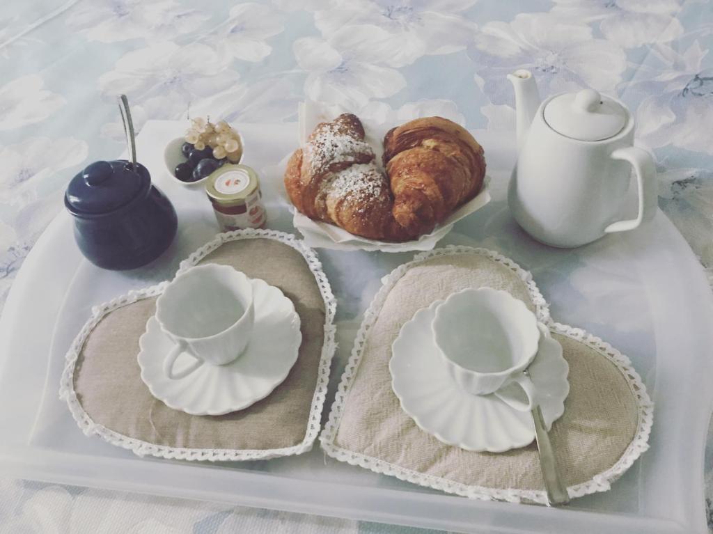 a tray with plates and cups and pastries on it at Archè in Salerno
