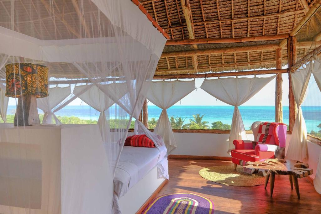 a bedroom with a bed and a view of the ocean at Jua Retreat in Michamvi