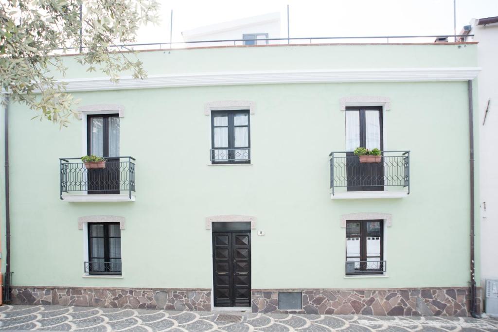 un edificio blanco con puertas y ventanas negras en Green House en Villaputzu