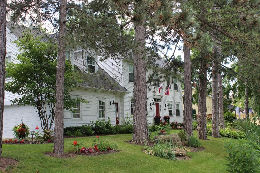 a white house with trees in the yard at Darlington House Bed and Breakfast in Niagara-on-the-Lake