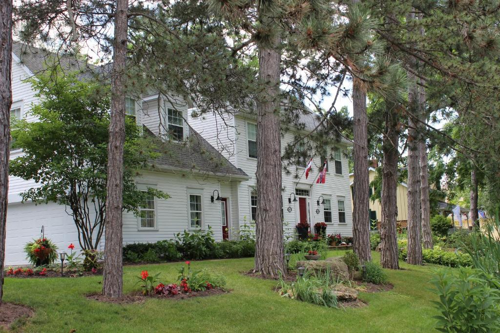 a white house with trees in the yard at Darlington House Bed and Breakfast in Niagara on the Lake