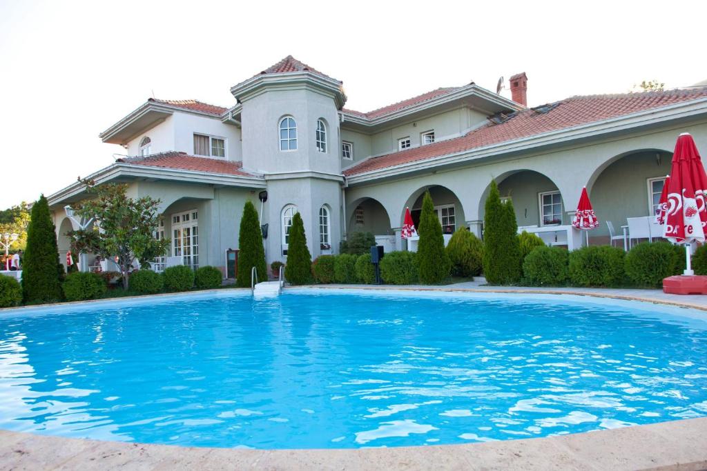 a large house with a swimming pool in front of it at Sunny House in Skopje