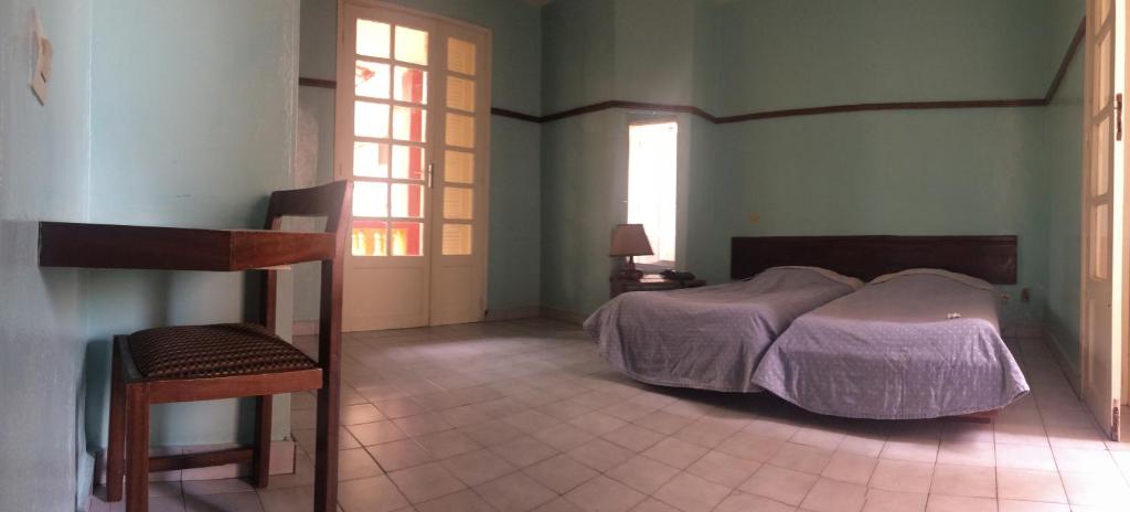 Ένα ή περισσότερα κρεβάτια σε δωμάτιο στο Hôtel Saint-Louis Sun Dakar