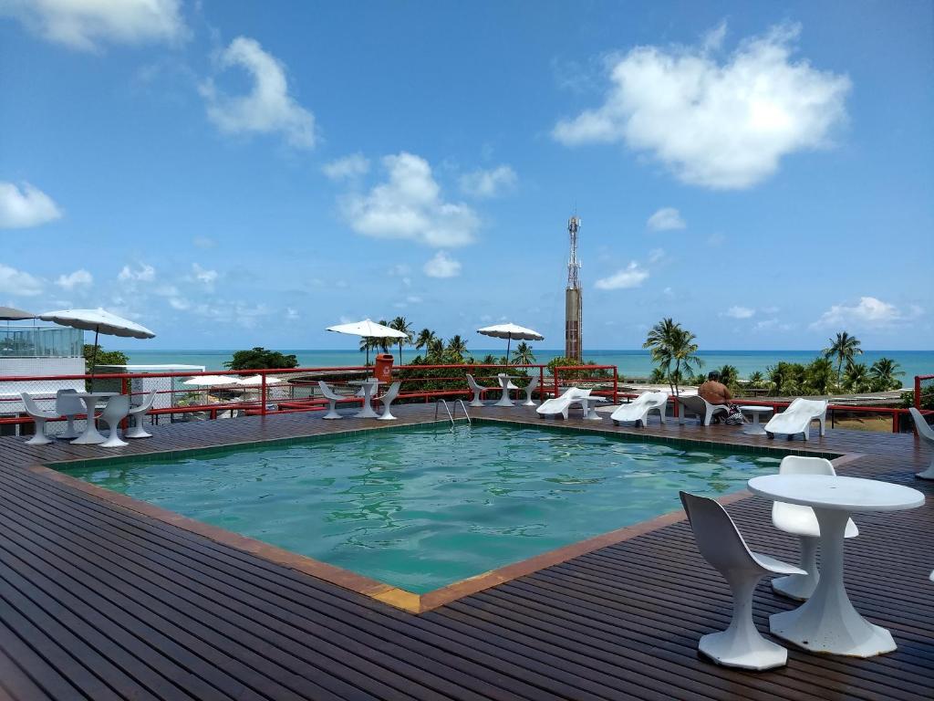 a pool on a deck with chairs and a table at AP 219 Victory Flat em Tambaú in João Pessoa