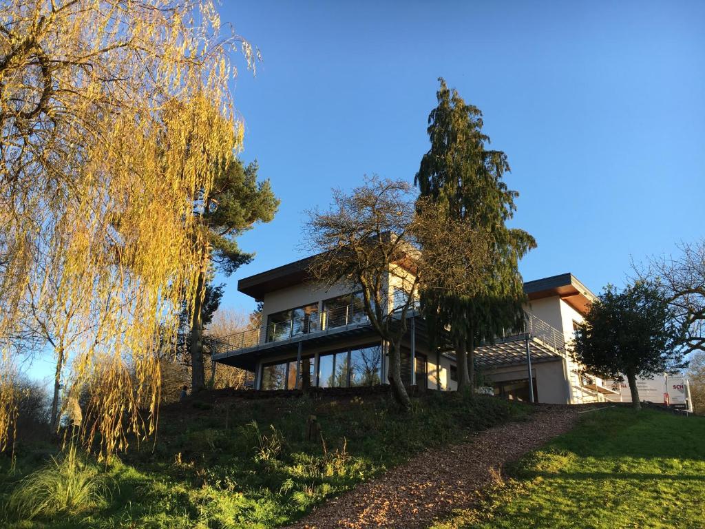 een huis op een heuvel met bomen op de voorgrond bij Haagalm Terrasse, Garten in Nonnweiler