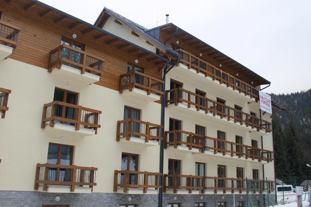 a large white building with wooden balconies at Apartment Lúčky - Jasná in Demanovska Dolina