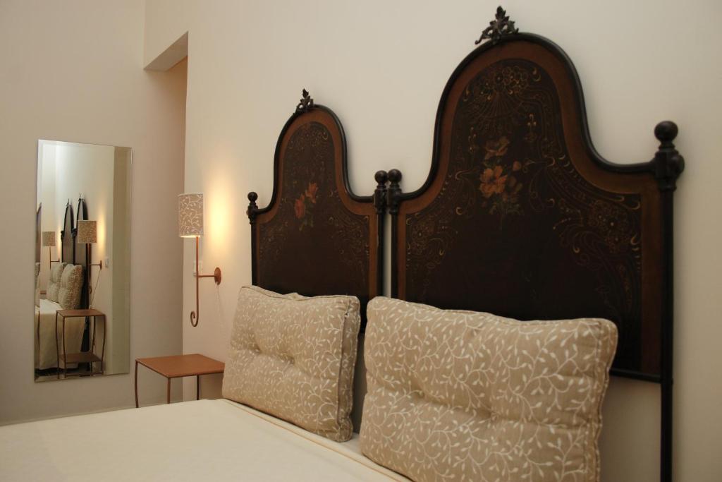 a bed with a large wooden headboard and two pillows at B&B Casa Ruffino in Balestrate