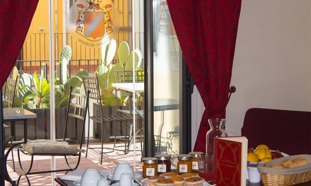 una mesa con comida en ella con cortinas rojas en Principe Di Francalanza, en Catania