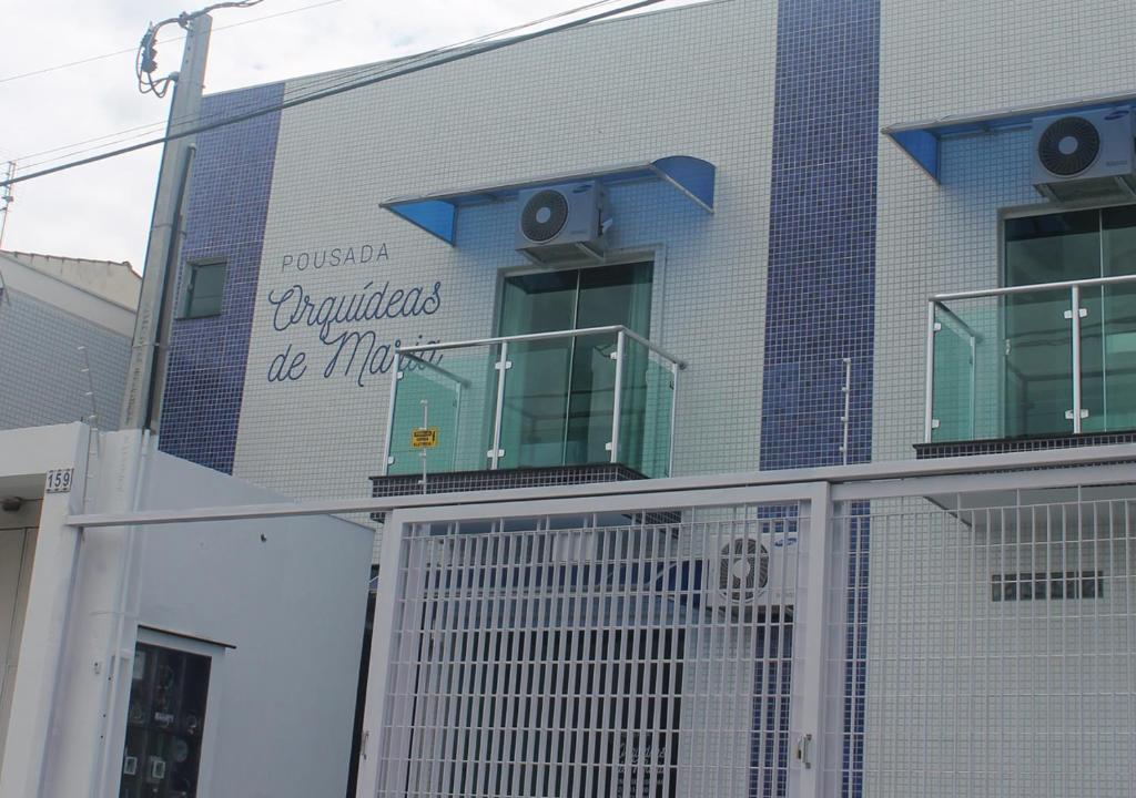 un bâtiment avec un panneau sur son côté dans l'établissement Pousada Orquideas de Maria, à Aparecida
