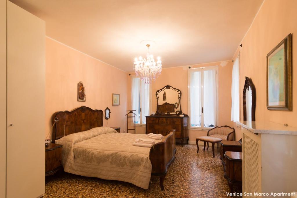 1 dormitorio con cama y lámpara de araña en Venice San Marco Apartment, en Venecia