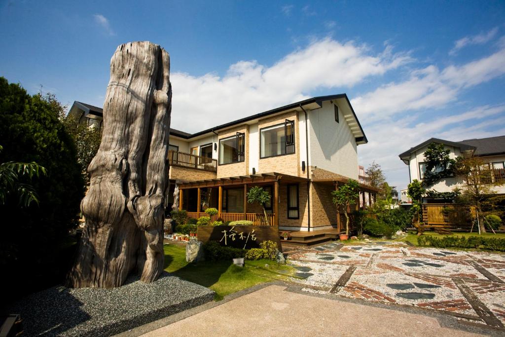 una casa con un tronco de árbol en el patio en 檜木居民宿 - 立案證號 一六三 - 一六八 - 一七零, en Jian