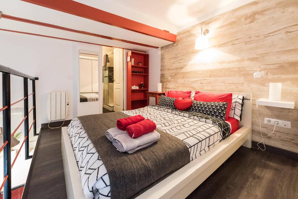 マドリードにあるLoft en Travesía de Cabestreros - Lavapiésのベッドルーム1室(赤い枕が付いた大型ベッド1台付)
