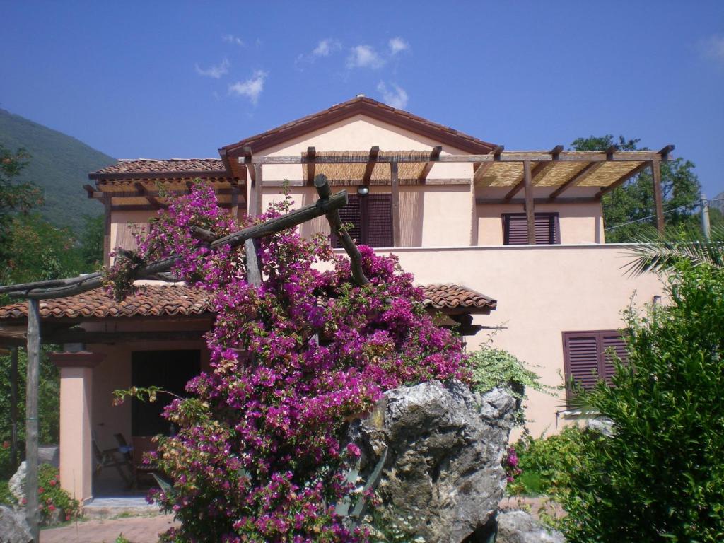 una casa con flores púrpuras delante de ella en Villa Manatí en Maratea
