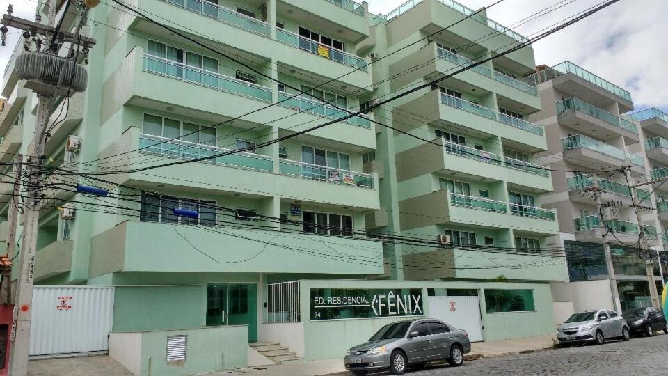 un edificio con coches estacionados frente a él en Apartamento em Arraial do Cabo, en Arraial do Cabo