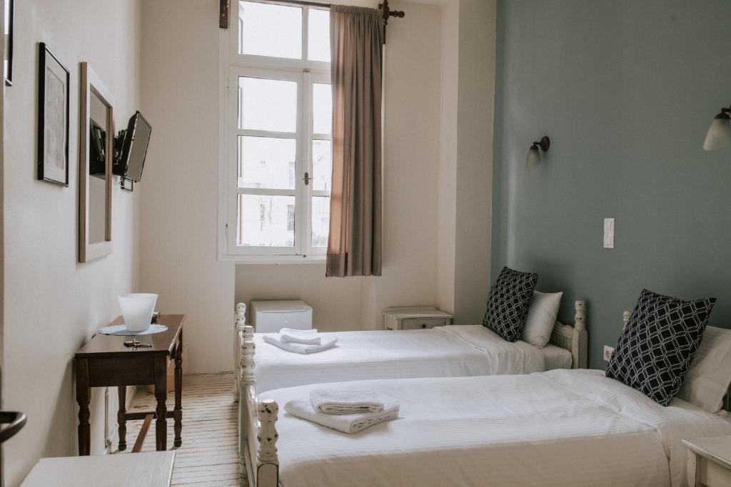 2 camas en una habitación pequeña con ventana en Faidra, en Chios