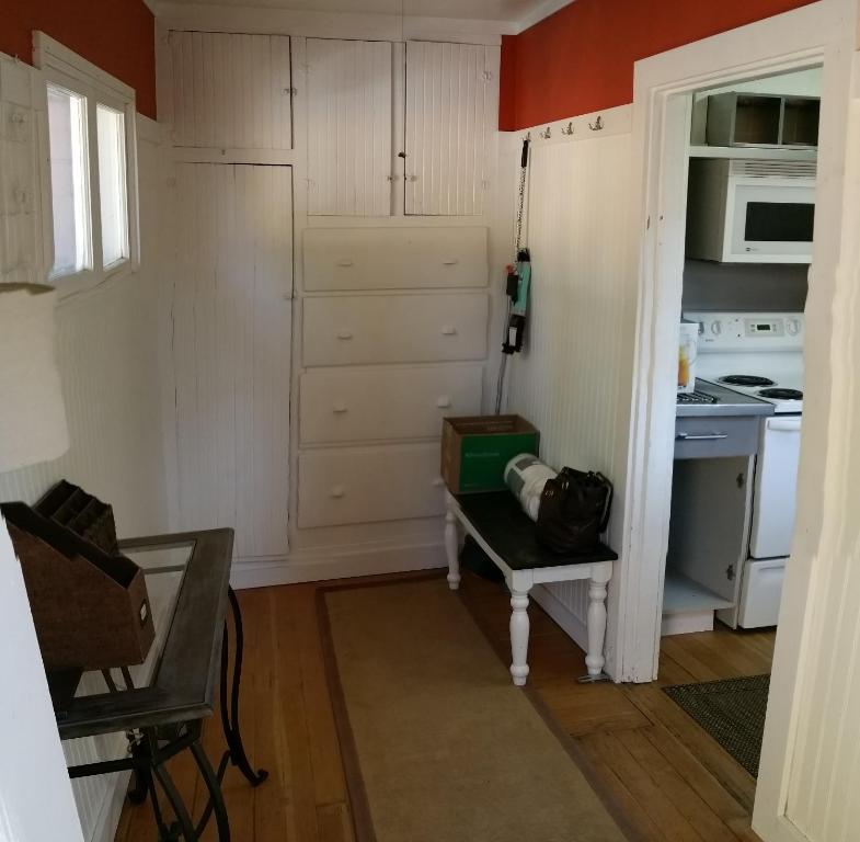 una cocina con armarios blancos y una mesa en una habitación en The Red Smarthouse King ❤ of Downtown W/D WiFi, en Klamath Falls