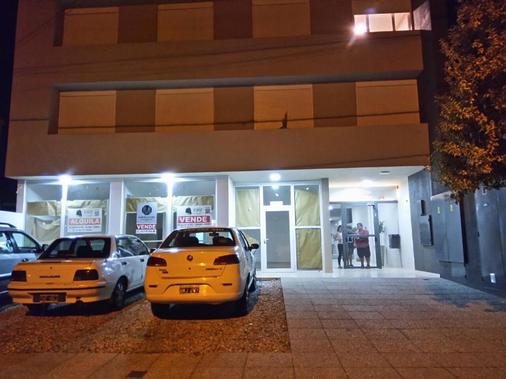 two cars parked in front of a building at night at Casablanca in Villa María