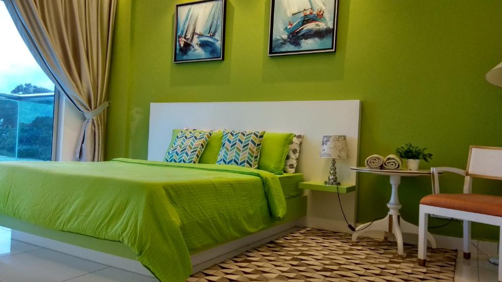 a green bedroom with a bed and a window at INFA - Muslim House @ Seroja Apartment, Johor Bahru in Johor Bahru