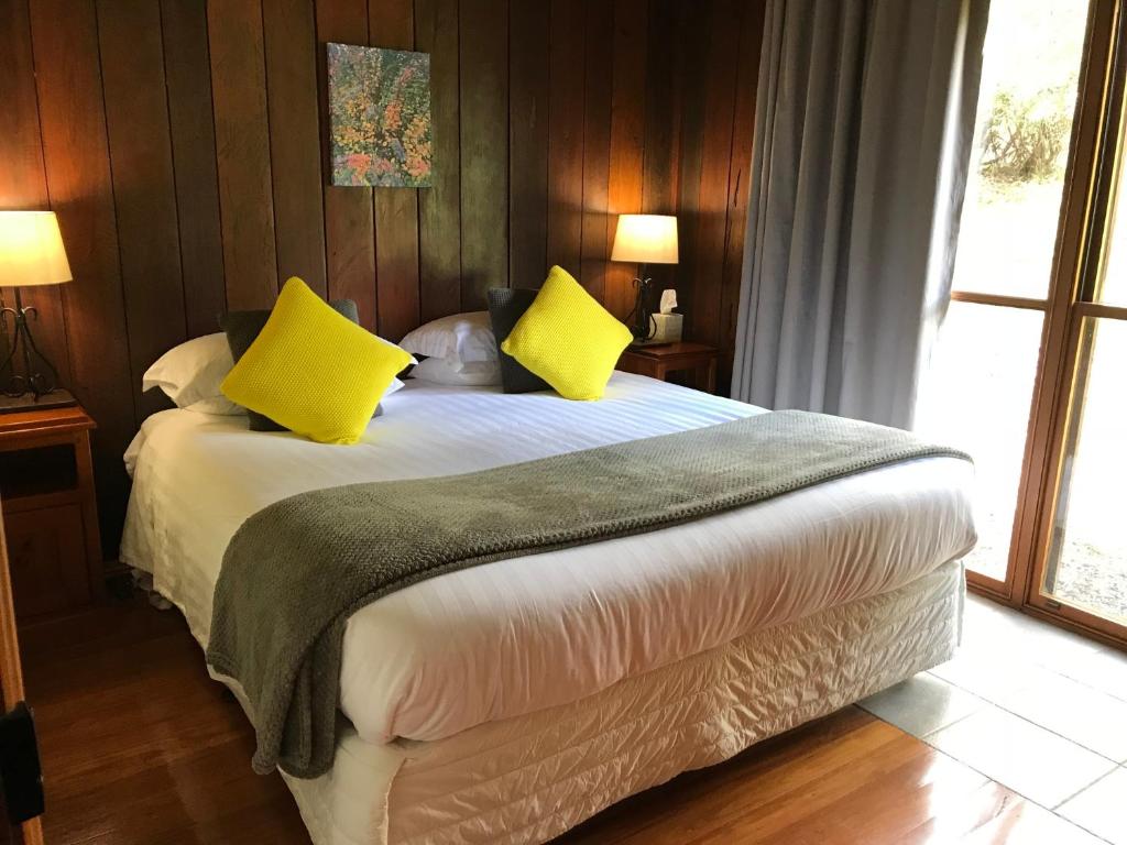 - une chambre avec un grand lit et des oreillers jaunes dans l'établissement Ghost Hill Road Retreat, à Bilpin