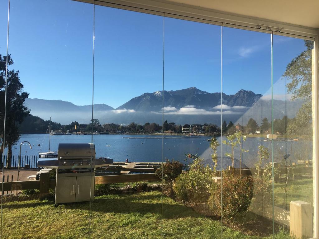 una finestra con vista sul lago e sulle montagne di Aiwinco Departamento Pucón a Pucón