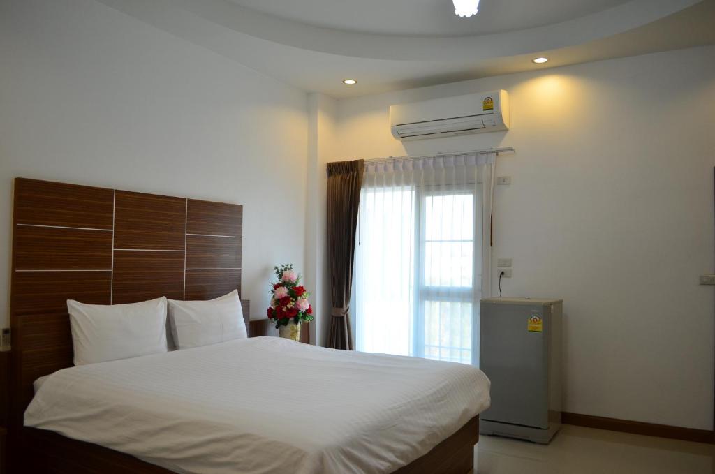 a bedroom with a large bed and a window at Ketsara Hotel in Maha Sarakham
