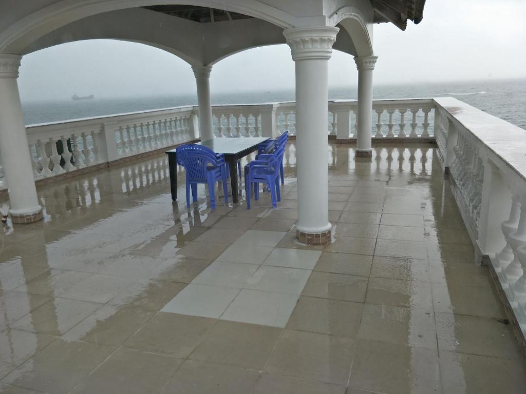 - une terrasse couverte avec des chaises bleues et une table sur une jetée dans l'établissement Nancy Villa, à Vung Tau
