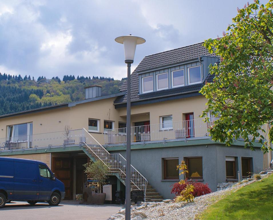 une camionnette bleue garée devant un bâtiment dans l'établissement Weingut Roth, à Kindel