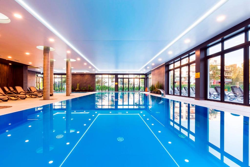 - une piscine d'eau bleue dans un bâtiment dans l'établissement Apartament z Wellness Polanki Park Kołobrzeg, à Kołobrzeg