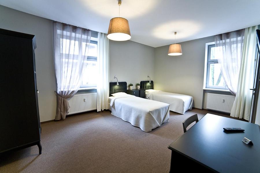 a hotel room with two beds and a table at Avalis Apartamenty in Poznań
