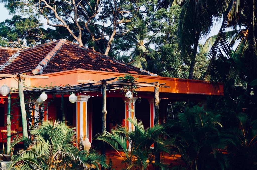 ein Orangenhaus mit Palmen davor in der Unterkunft Allens home stay in Jaffna