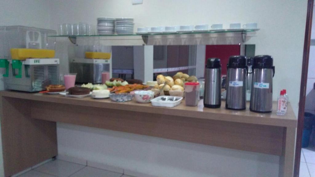a counter with food and drinks on a table at Hotel Village Premiun in Bebedouro