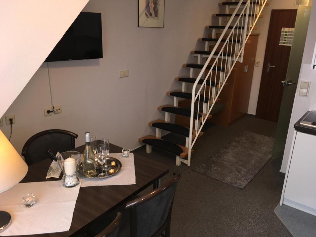 ein Esszimmer mit einem Tisch und einer Treppe in der Unterkunft Apartment 47 in Sindelfingen