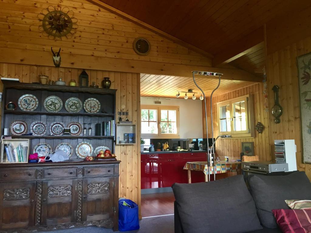 - un salon avec un canapé et un mur en bois dans l'établissement Ferienwohnung im Chalet Firn - OG, à Bürchen