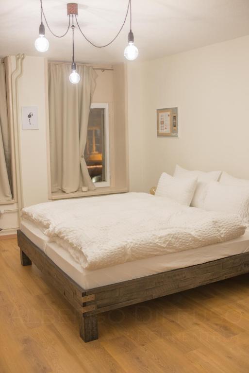 a bedroom with a large bed with white sheets at Albergo Diffuso Porrentruy in Porrentruy