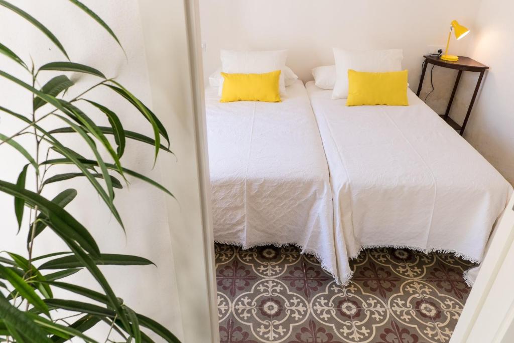 ポリェンサにあるBlue Casita ETV 7845のベッドルーム1室(黄色い枕と植物付)