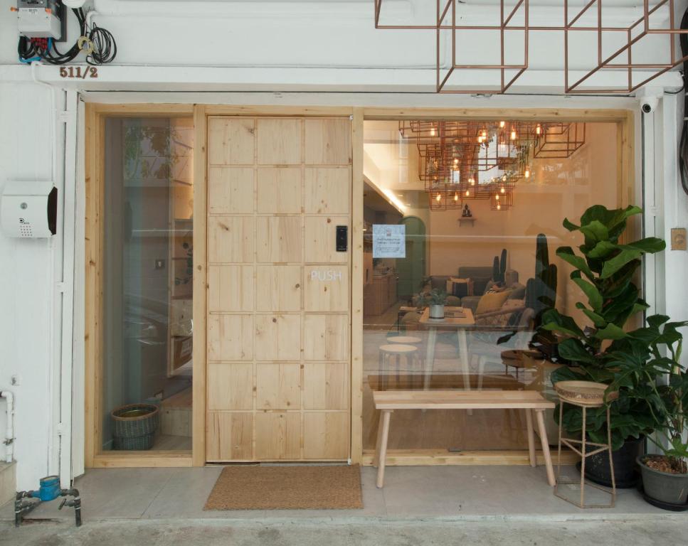 una puerta corredera de cristal en una habitación con mesa en Pinto Hostel, en Bangkok