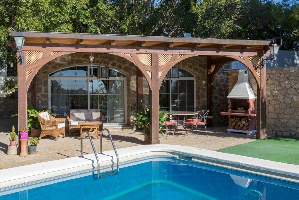 a pergola with a swimming pool in a backyard at Casita Cerrillo en Villa de Nijar con piscina in Níjar