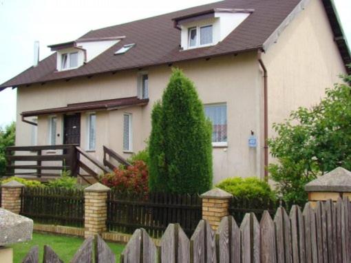 a house with a wooden fence in front of it at Cichy Zakątek in Sianozety