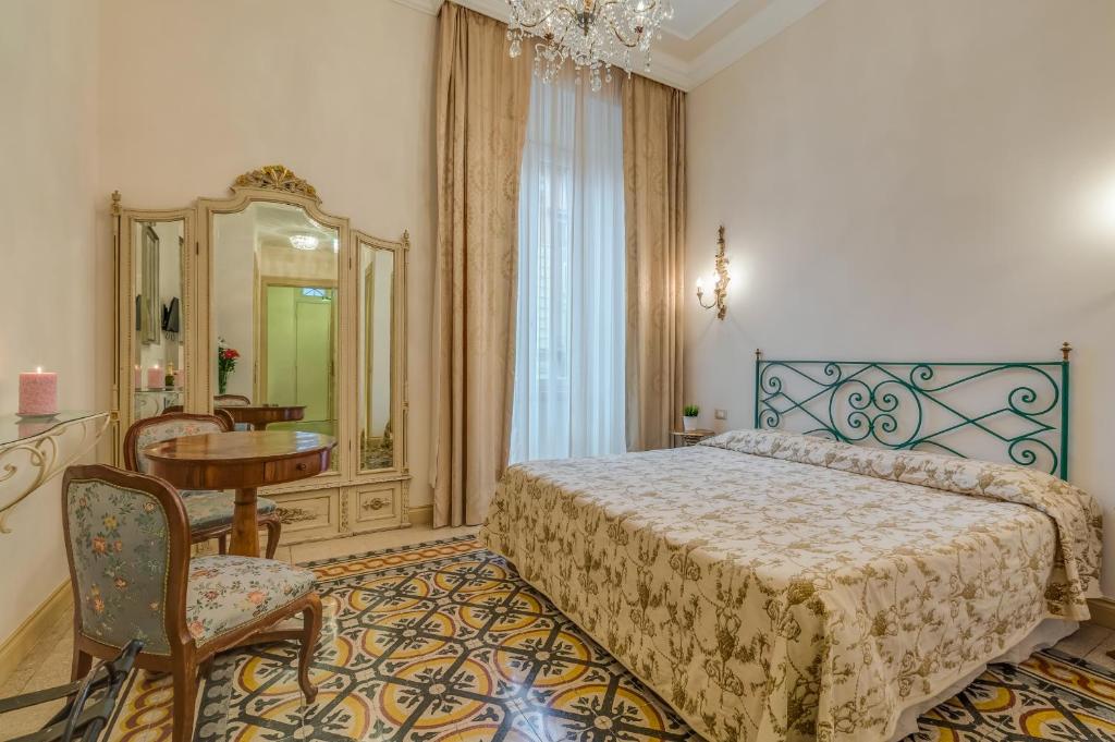 Schlafzimmer mit einem Bett, einem Tisch und einem Spiegel in der Unterkunft Rome Charming Suites in Rom