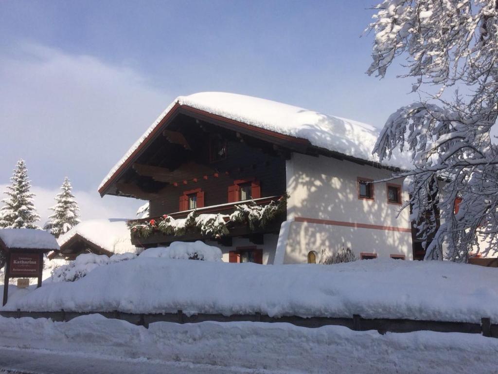 uma casa coberta de neve na frente em Gästehaus Katharina em Hochfilzen