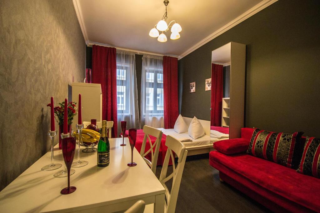 mały salon z czerwoną kanapą i stołem w obiekcie Ruterra Apartment Cimburkova w Pradze
