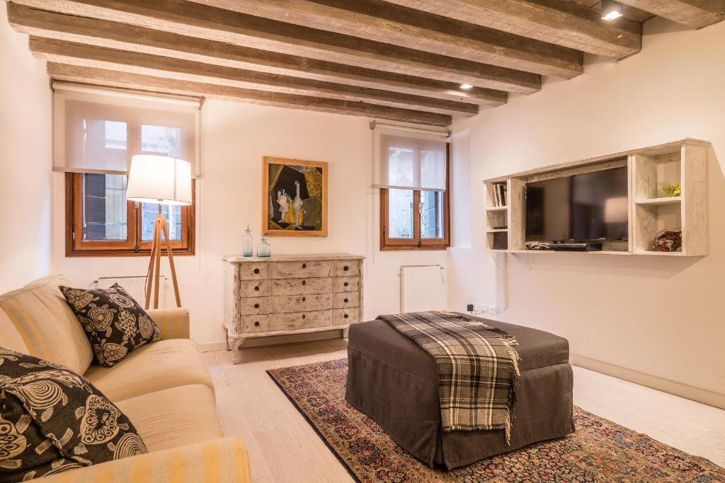 uma sala de estar com um sofá e uma televisão em SAN POLO 2140 IN THE HEART OF VENICE em Veneza